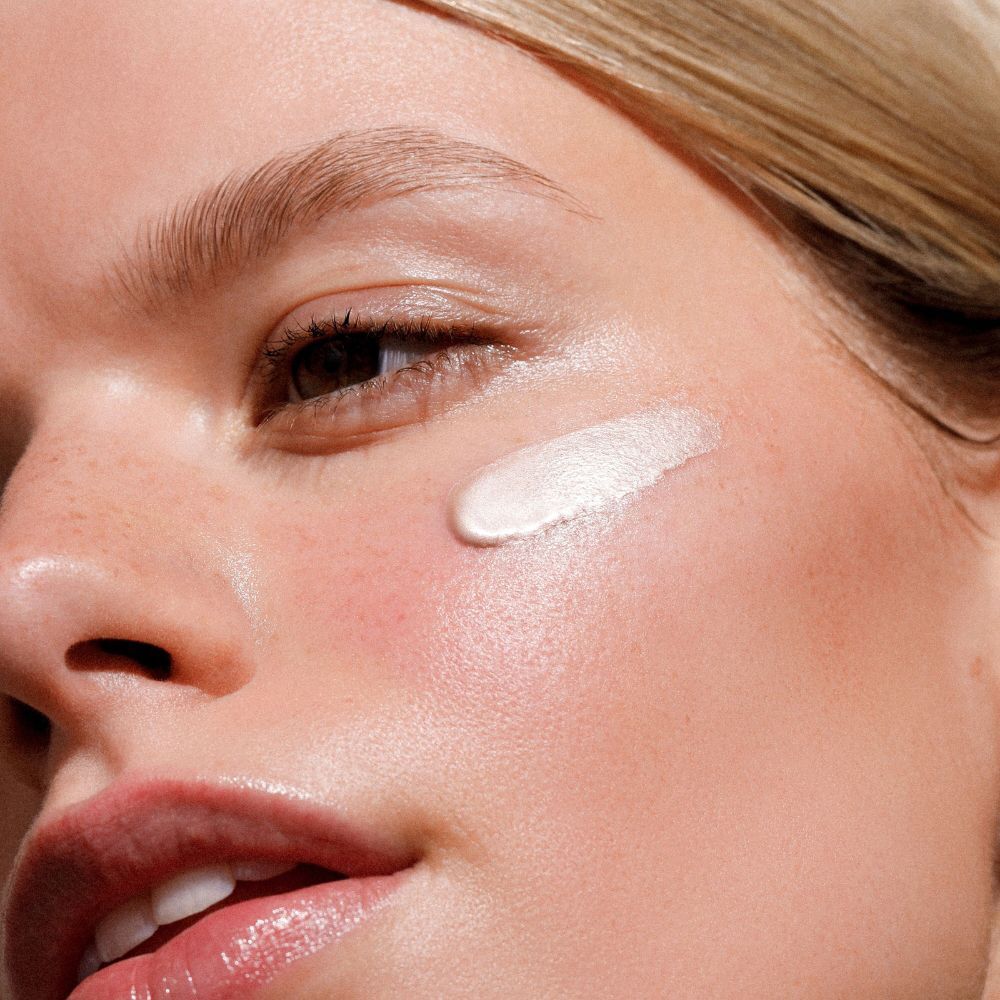 Una macchia di Dr. Hauschka Illuminating Fluid sulla guancia di una donna.
