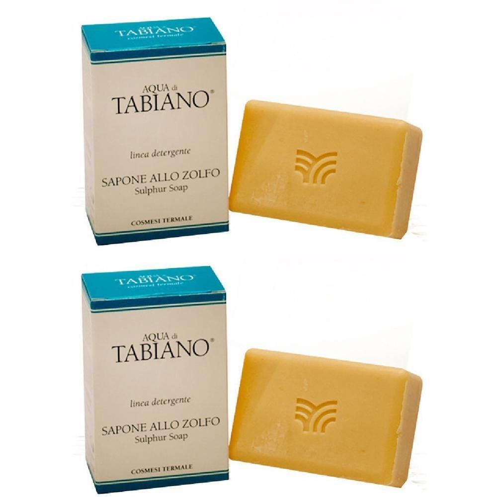 Due confezioni di sapone allo zolfo Tabiano. Pezzi di sapone gialli con logo, accanto alla confezione con informazioni sul prodotto.
