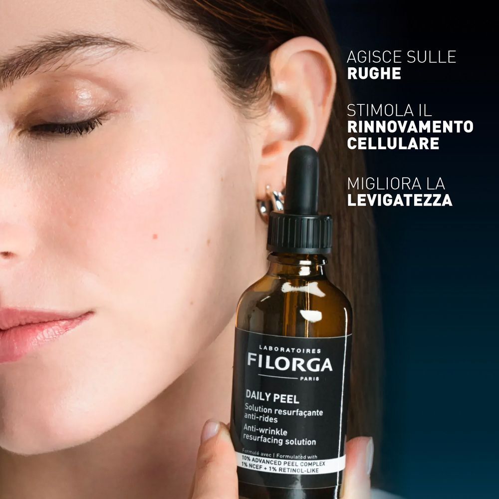 Donna che tiene un flacone di soluzione Filorga Daily Peel Anti-Wrinkle.
