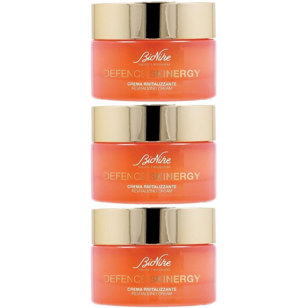 Tre vasetti di crema BioNike Defence Skinergy con tappi dorati.
