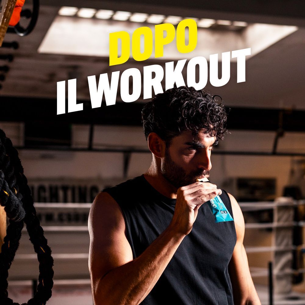 Un uomo mangia una barretta proteica ENERVIT dopo l'allenamento.