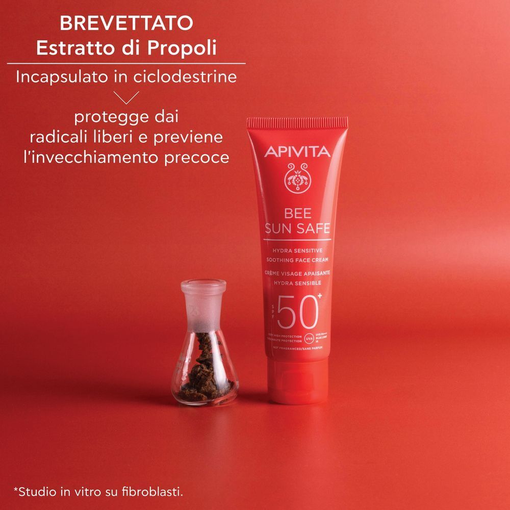 Tubetto rosso di crema solare viso APIVITA SPF 50+, vicino a una fiala con estratto di propoli.