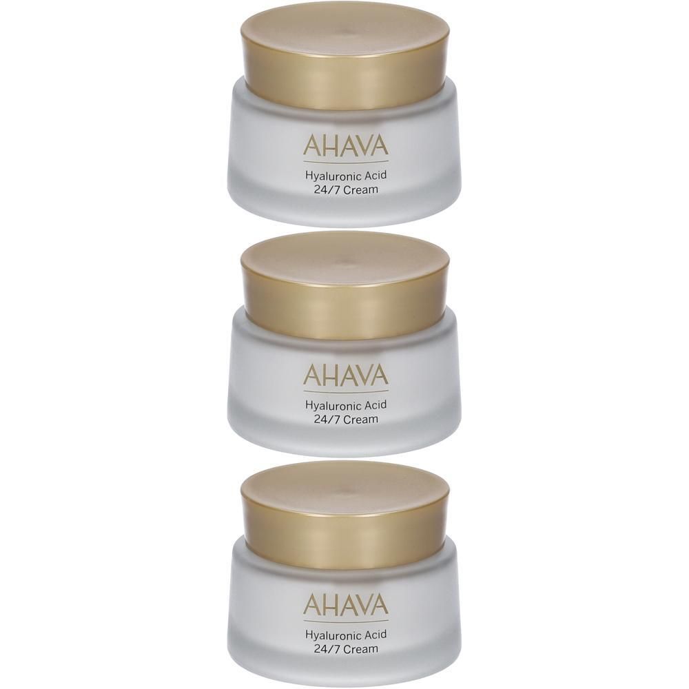 Tre vasetti di crema AHAVA Acido Ialuronico 24/7 con tappi dorati.