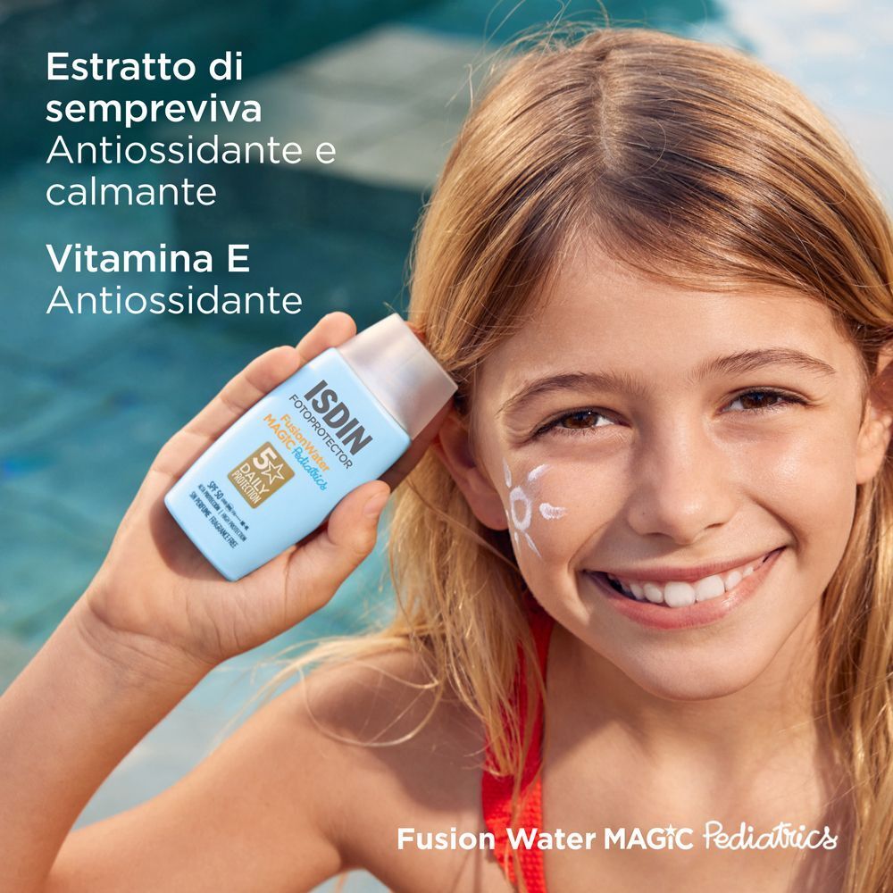 Bambina che tiene in mano un flacone di crema solare ISDIN Fotoprotector Fusion Water Magic Pediatrics, con antiossidanti.