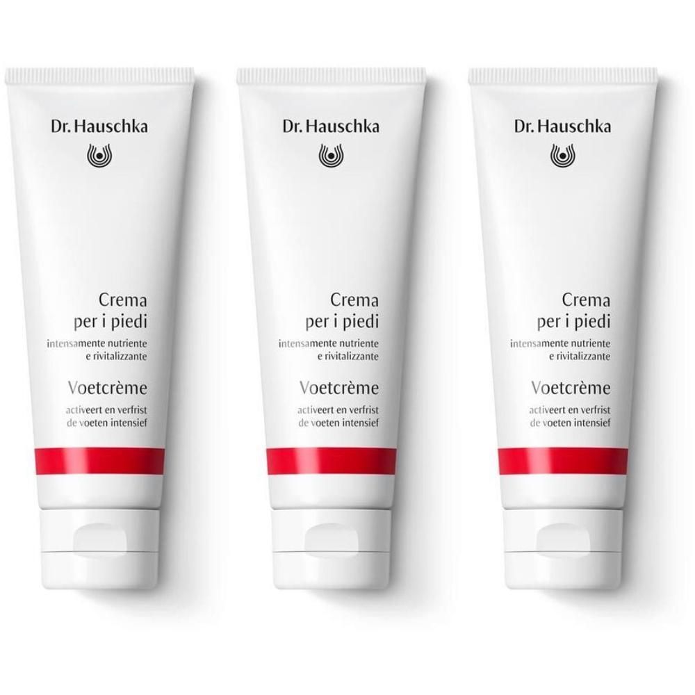 Tre tubi bianchi di Crema per i piedi Dr. Hauschka con una fascia rossa.