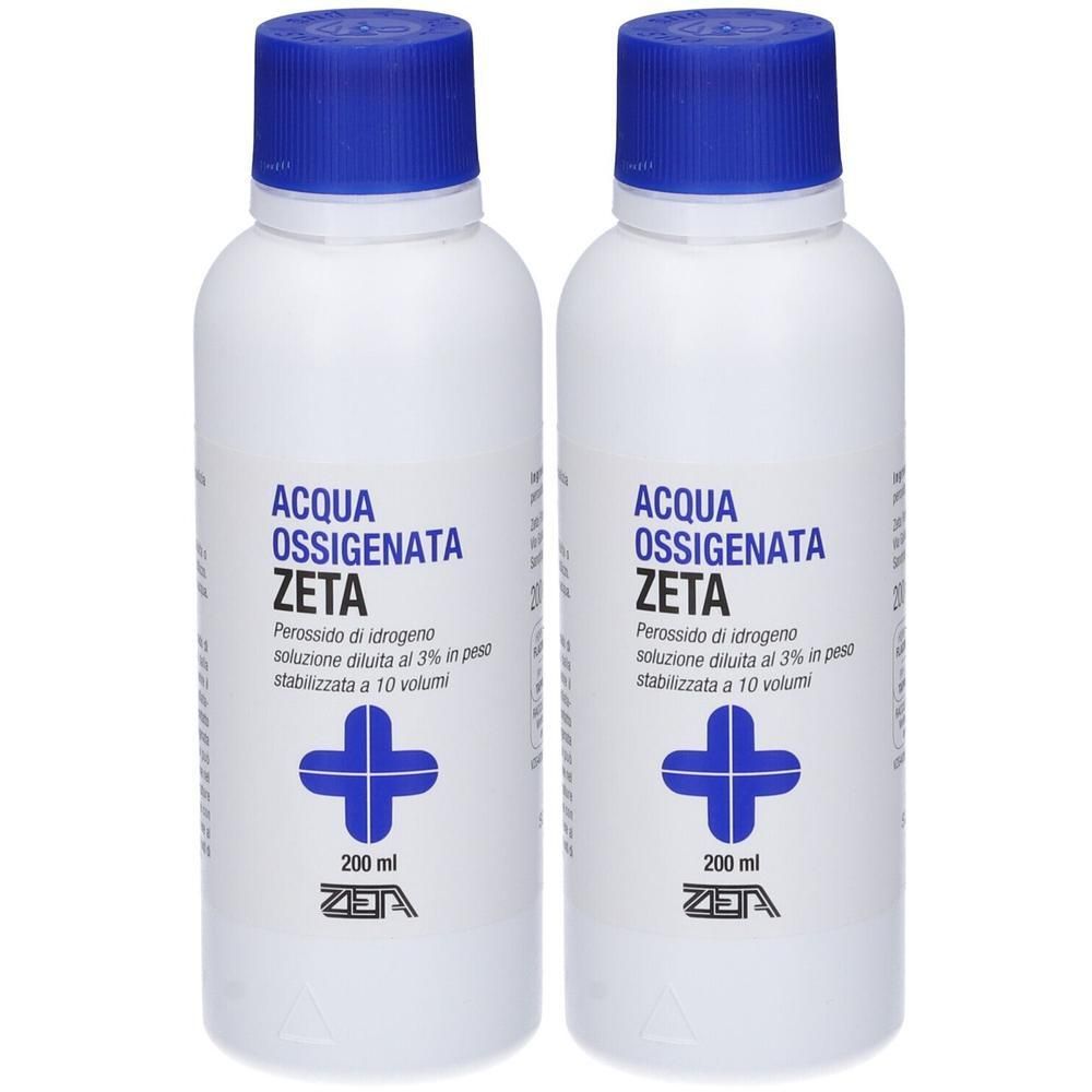 Due flaconi di Acqua Ossigenata Zeta al 3%. Tappo blu, flacone bianco con scritte blu e simbolo croce.