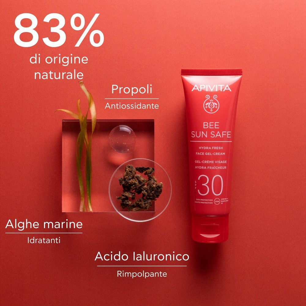 Tubetto rosso APIVITA Bee Sun Safe SPF 30 accanto agli ingredienti: propoli, alghe marine, acido ialuronico.
