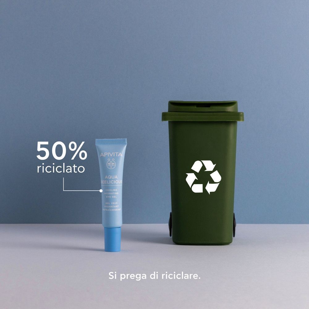 Gel occhi APIVITA Aqua Beelicious accanto a un bidone riciclaggio verde, 50% riciclato.