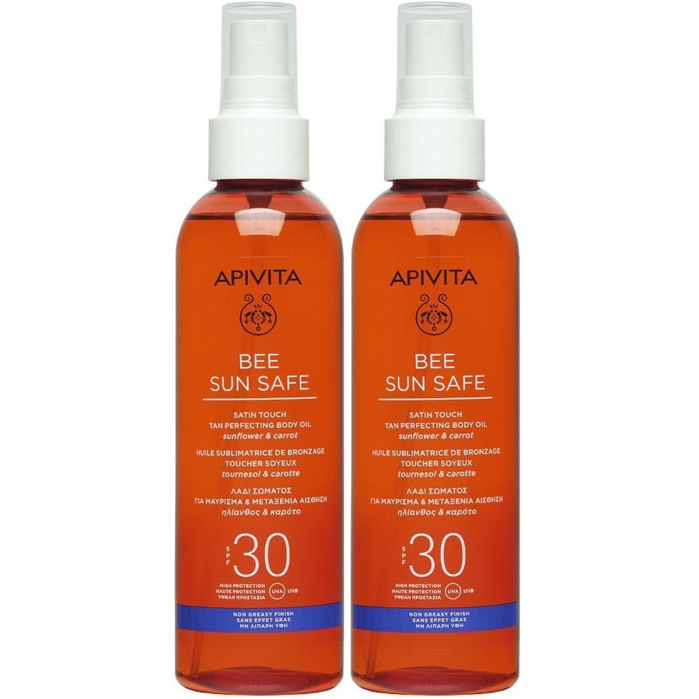 Due flaconi di olio solare APIVITA SPF30 con spray. Flaconi rossi con tappo bianco.