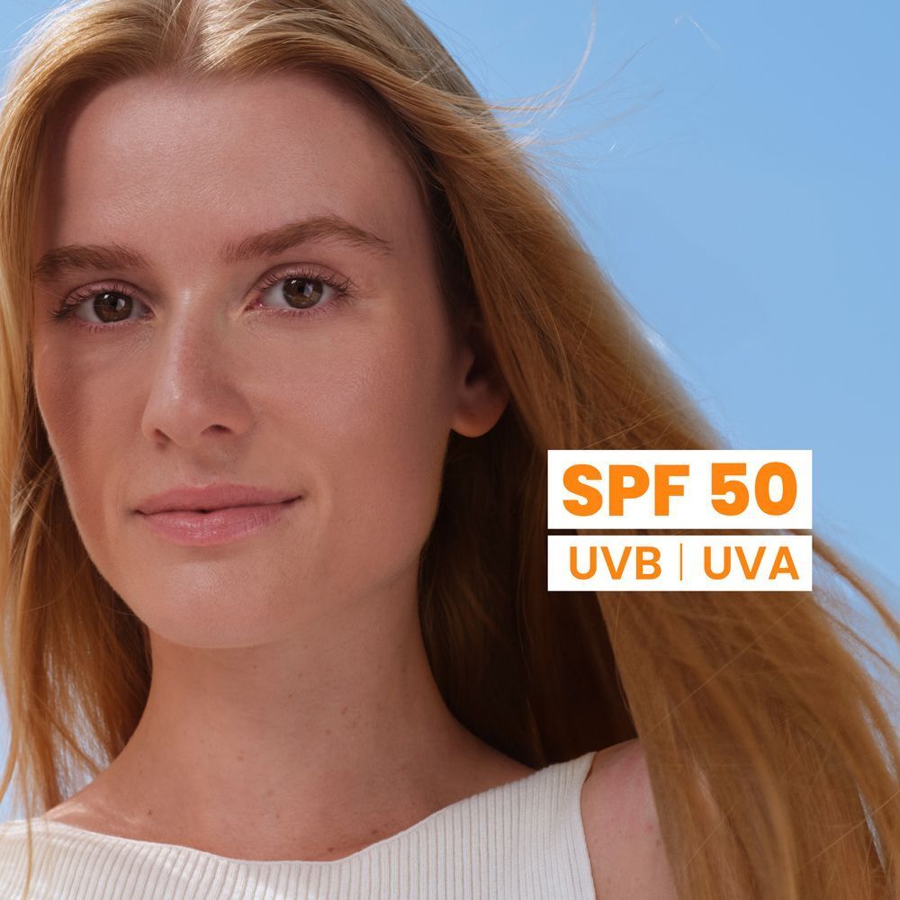 Ritratto di donna bionda con canottiera bianca, con protezione SPF 50 UVB UVA.