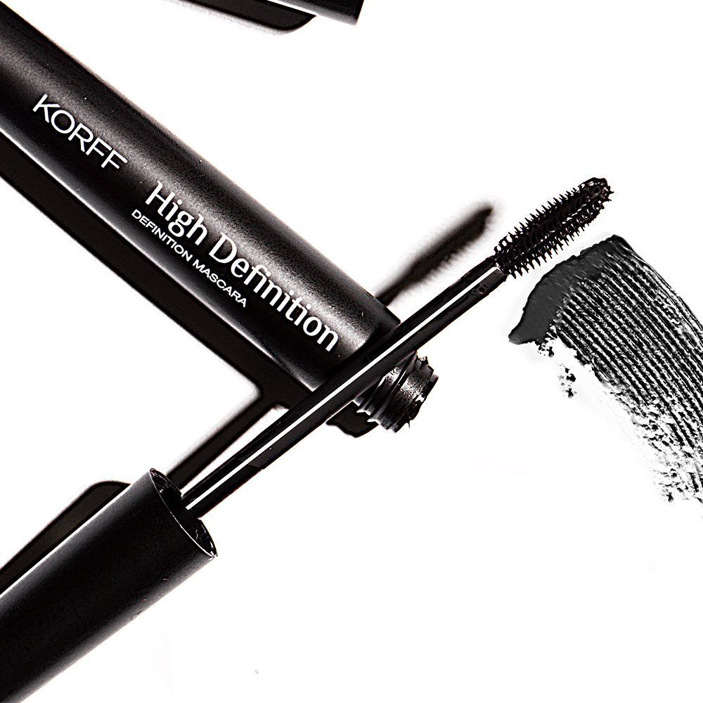 Primo piano di un tubetto di mascara nero con applicatore e traccia di mascara. KORFF High Definition.