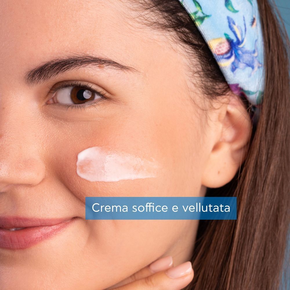 Primo piano di una donna che applica la crema idratante APIVITA Aqua Beelicious.