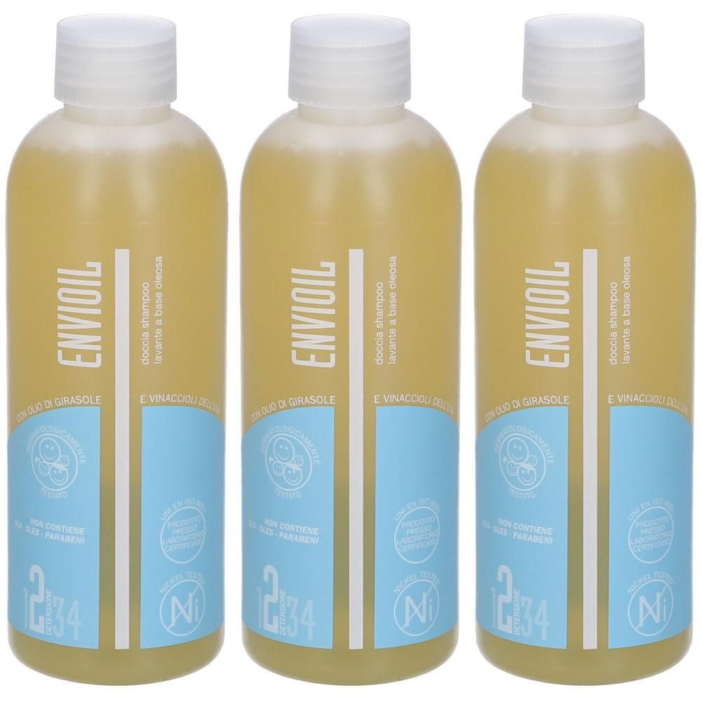 Tre flaconi di bagnoschiuma Envioil con liquido giallo e tappo bianco. Etichette blu con testo e simboli.