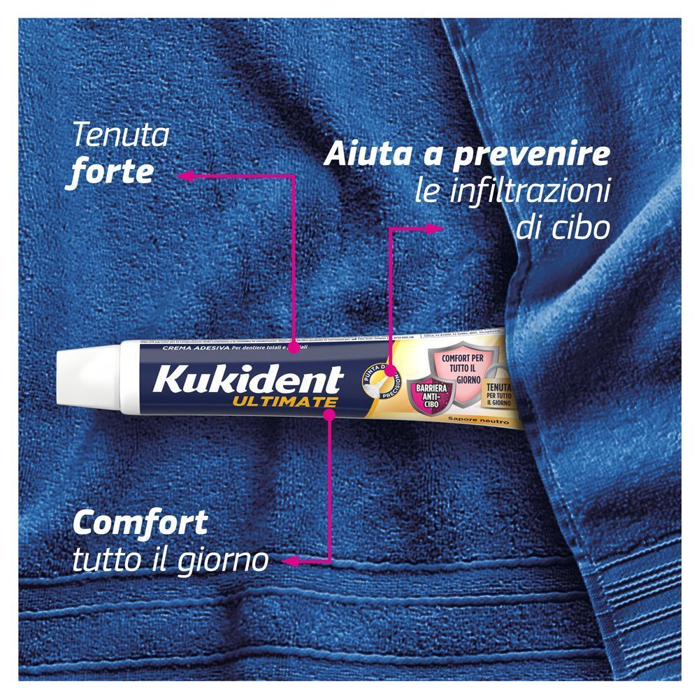 Crema adesiva Kukident Ultimate su un asciugamano blu.