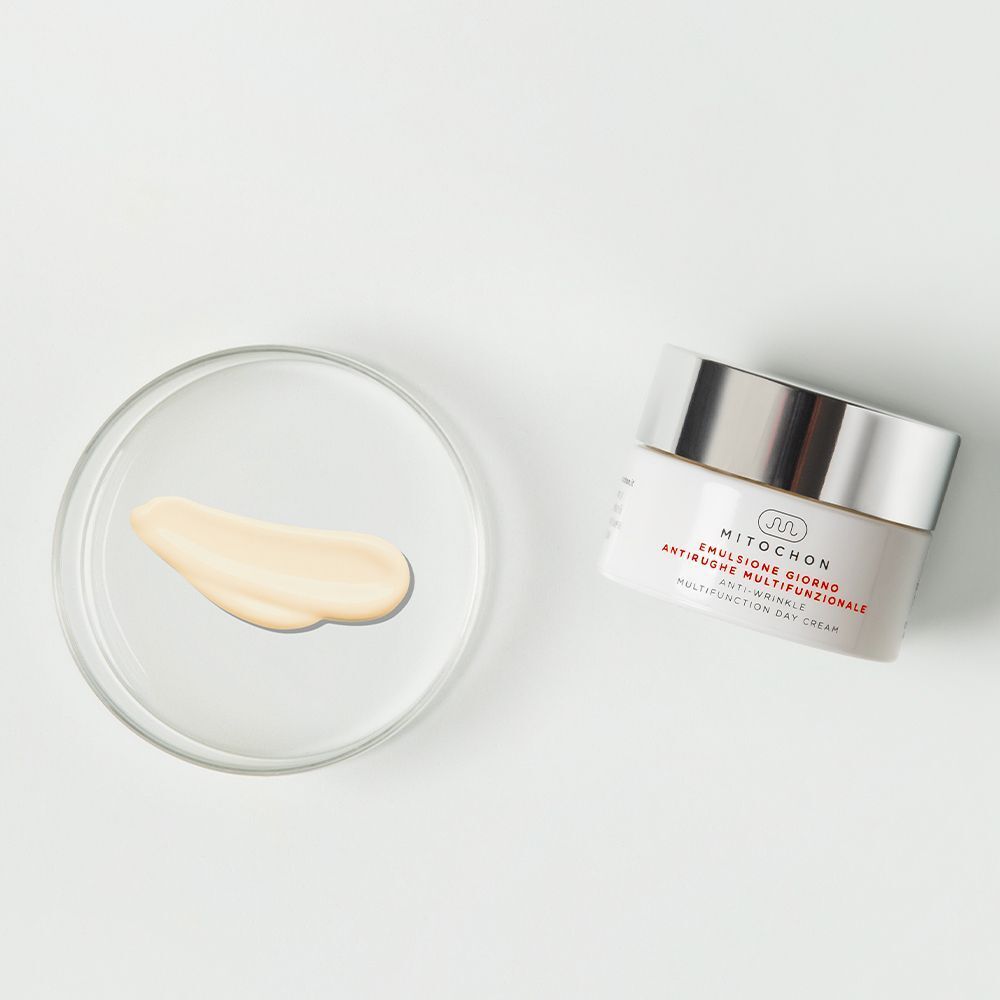 Vasetto di crema giorno multifunzionale Mitochon e un campione di crema in una capsula di Petri.