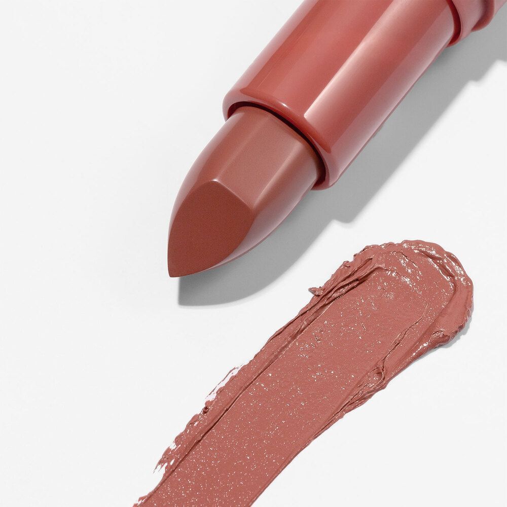 Un rossetto opaco color terra di Siena con punta smussata e campione di colore accanto.