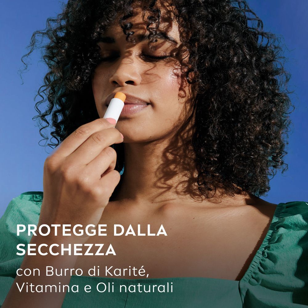 Donna applica burrocacao Labello Mango Shine, che protegge dalla secchezza.