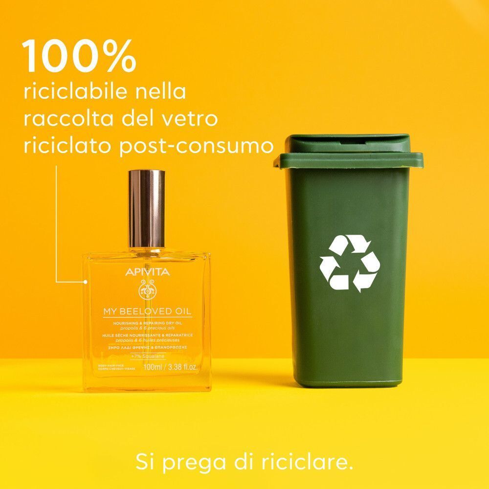 Flacone APIVITA My Beeloved Oil accanto a un bidone di riciclaggio verde. Testo: 100% riciclabile. Si prega di riciclare.
