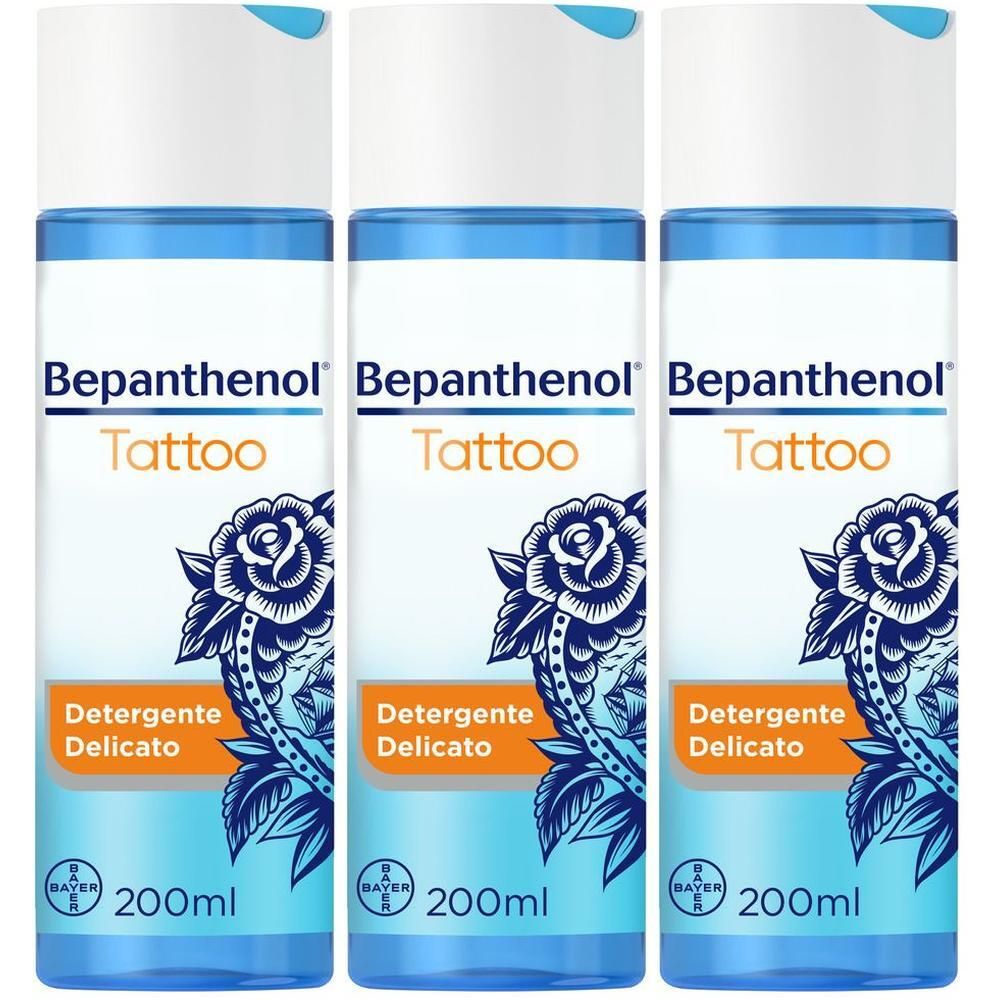 Tre flaconi di detergente Bepanthen Tattoo, 200ml ciascuno. Confezione blu e bianca con motivo floreale.