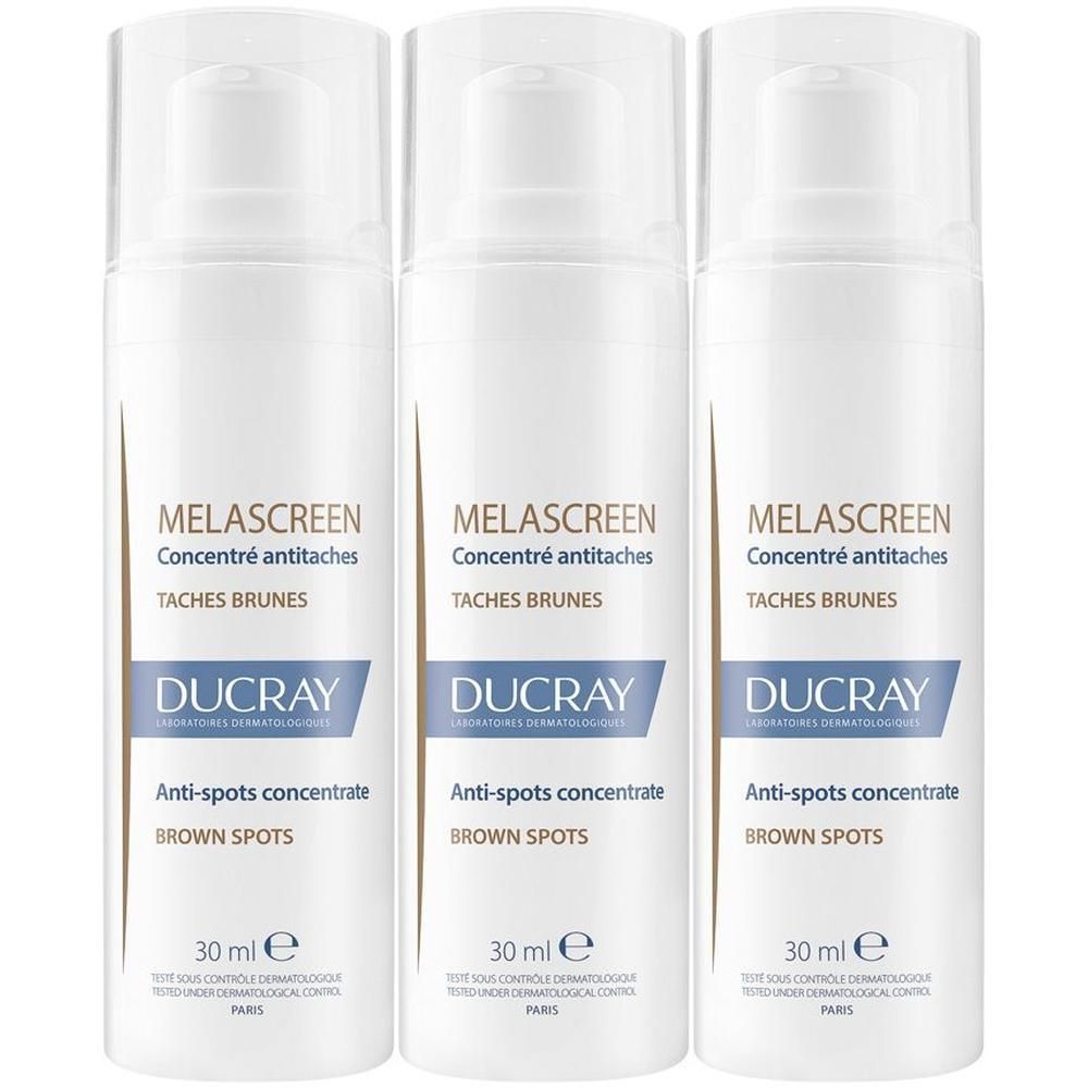 Tre flaconi bianchi Ducray Melascreen Concentrato anti-macchie con dispenser.