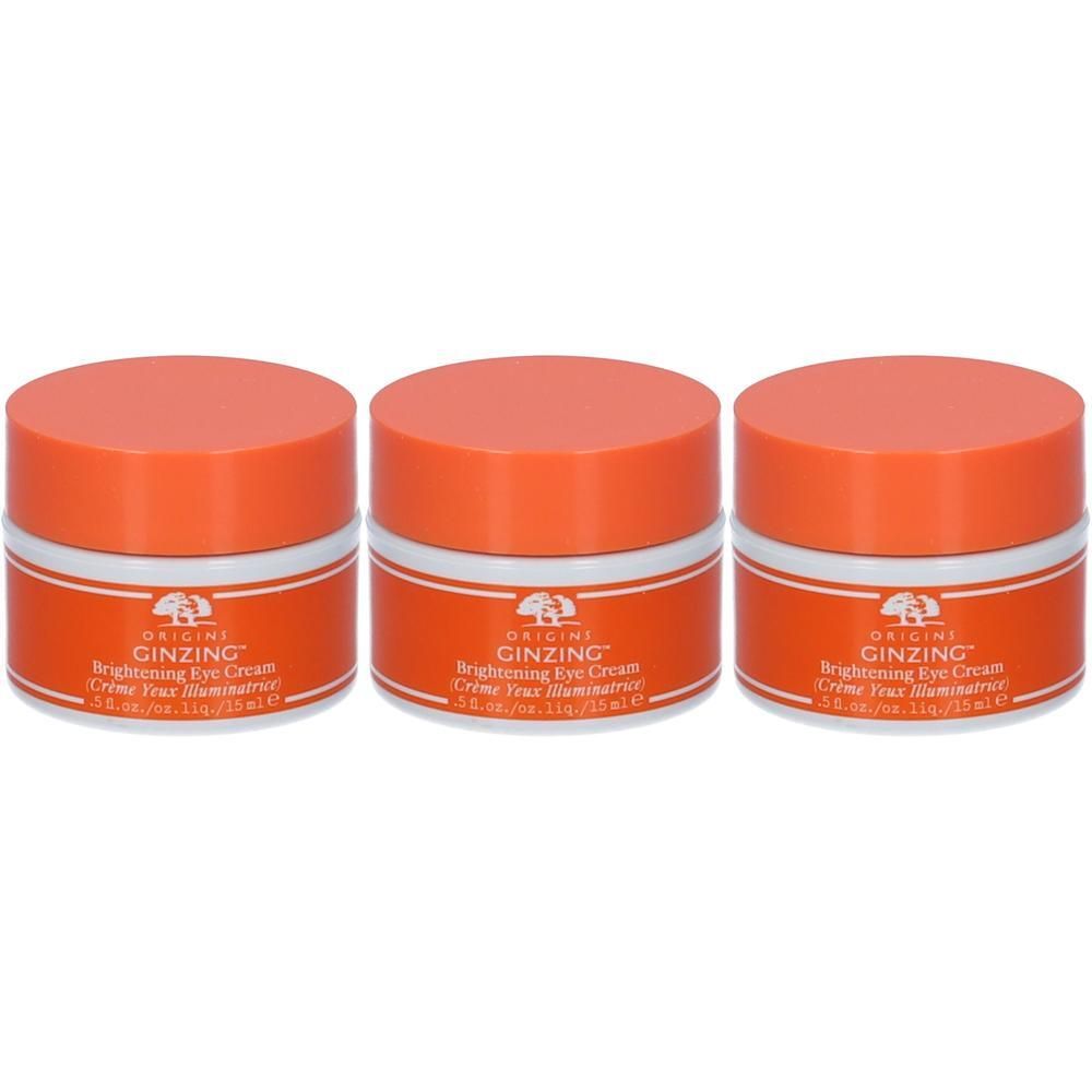 Tre vasetti di crema contorno occhi Origins Ginzing™ con tappi arancioni ed etichette bianche.