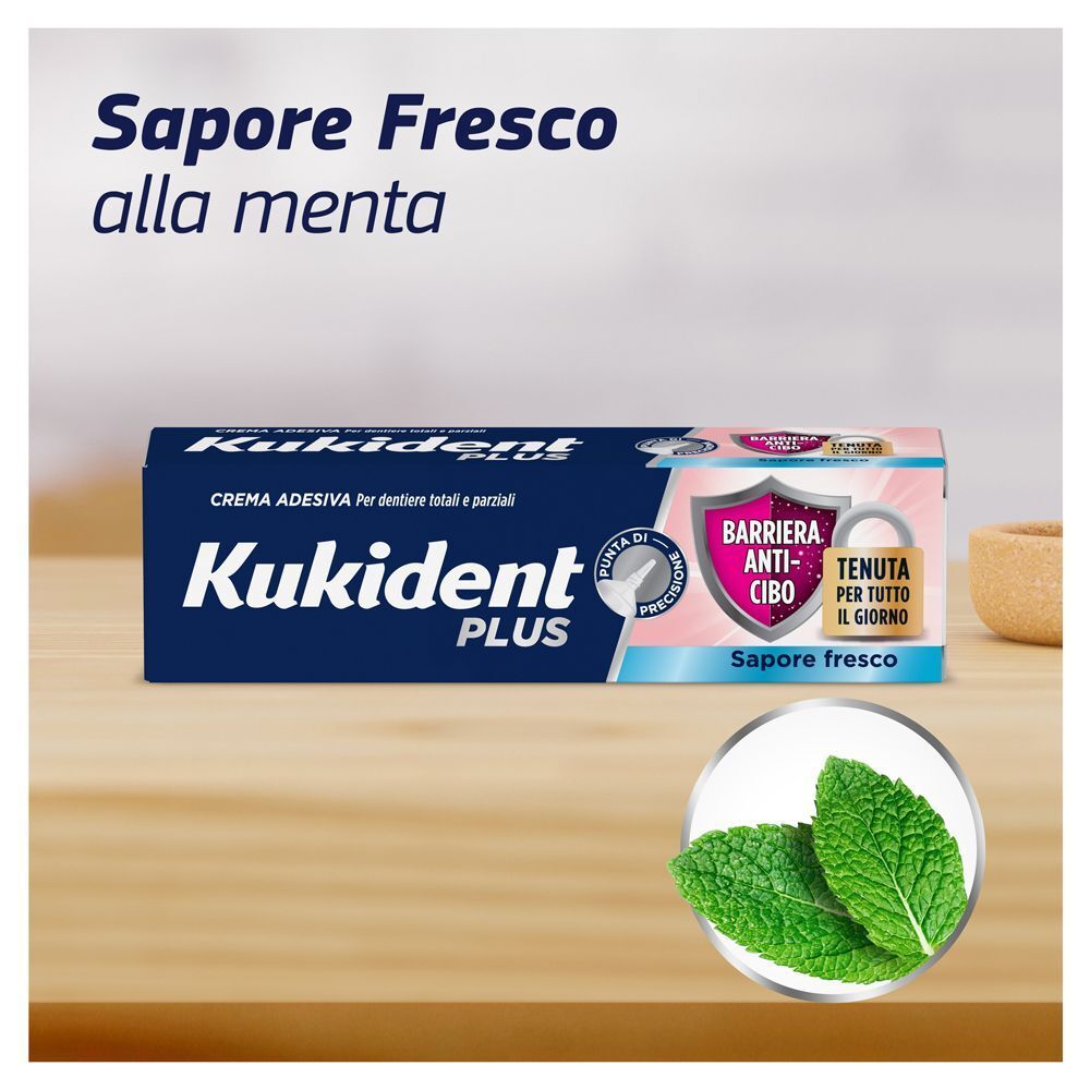 Confezione di crema adesiva Kukident Plus con foglie di menta e testo "Sapore Fresco".