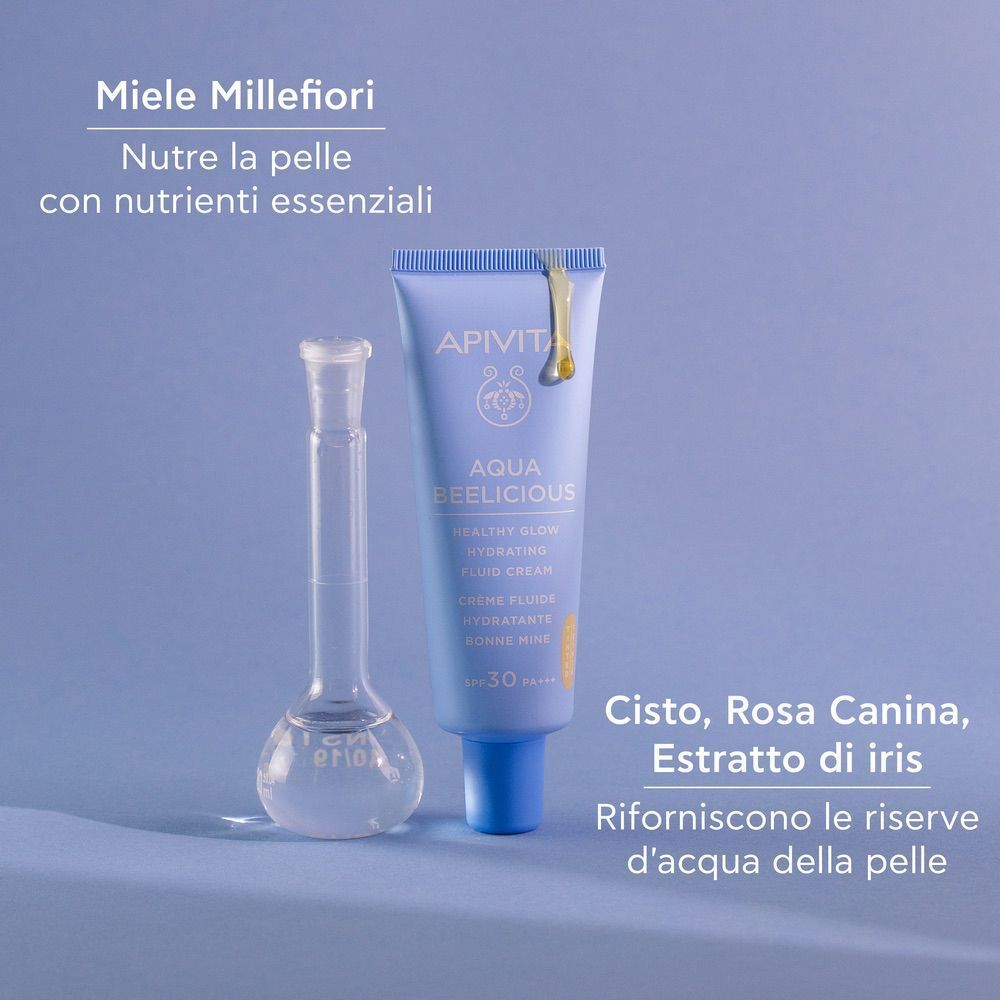 Fluido Apivita Aqua Beelicious accanto a un matraccio con miele.