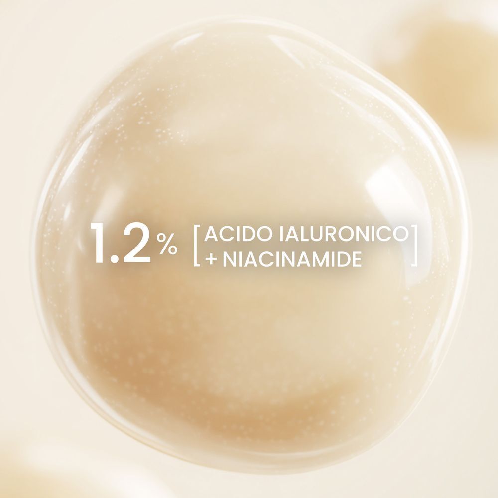 Macro di una goccia di siero con testo: '1.2% Acido Ialuronico + Niacinamide'.