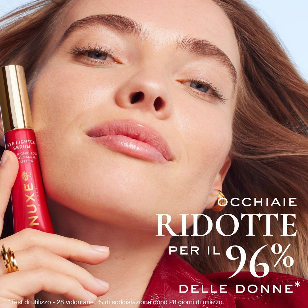 Una donna tiene in mano un tubetto di Nuxe Merveillance Lift Siero Contorno Occhi Illuminante.