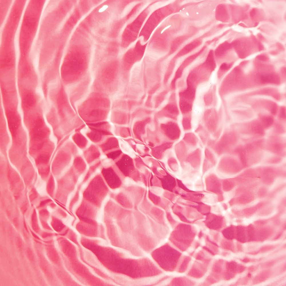 Primo piano di onde d'acqua rosa con riflessi di luce.