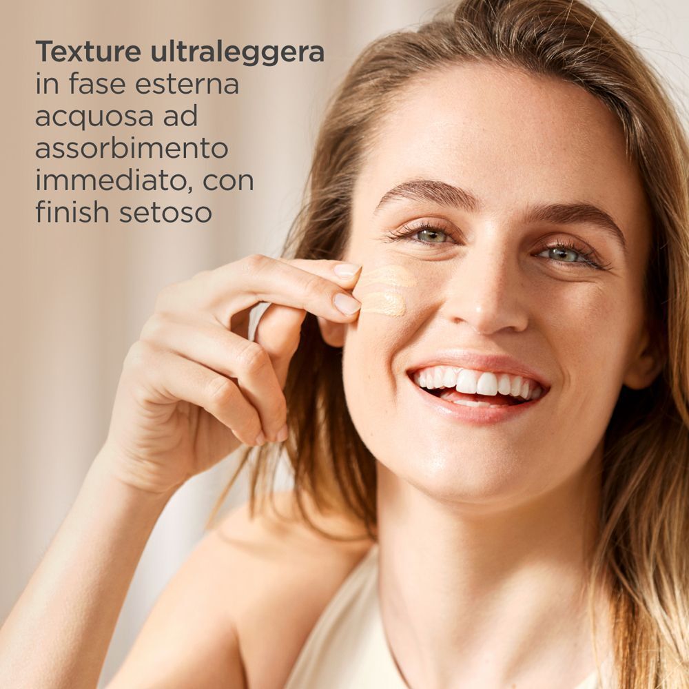 Donna applica ISDIN Fusion Water Magic Color Light SPF50 sul viso.