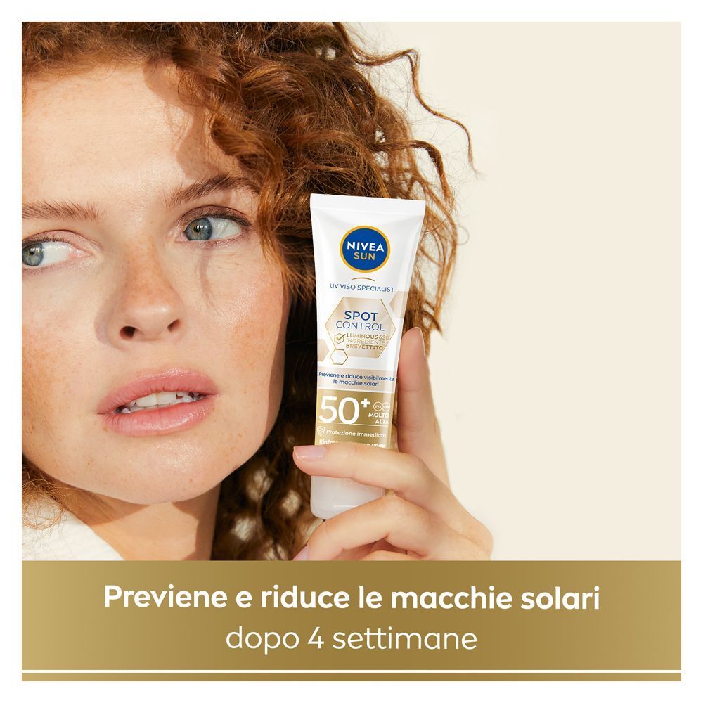 Donna tiene in mano crema solare viso Nivea Sun FP50+ anti-macchie.