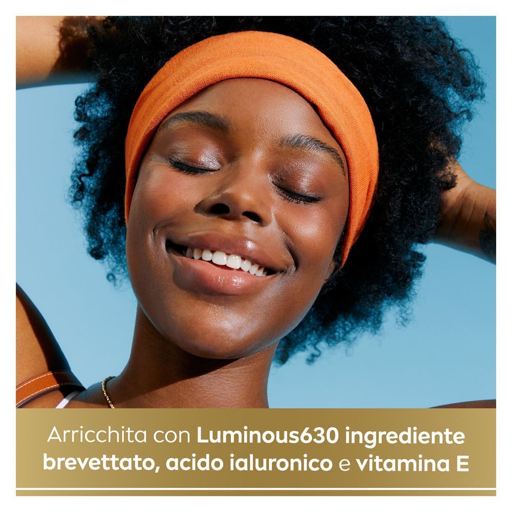Donna sorridente con crema solare viso Nivea Sun, arricchita Luminous630, acido ialuronico, vitamina E.