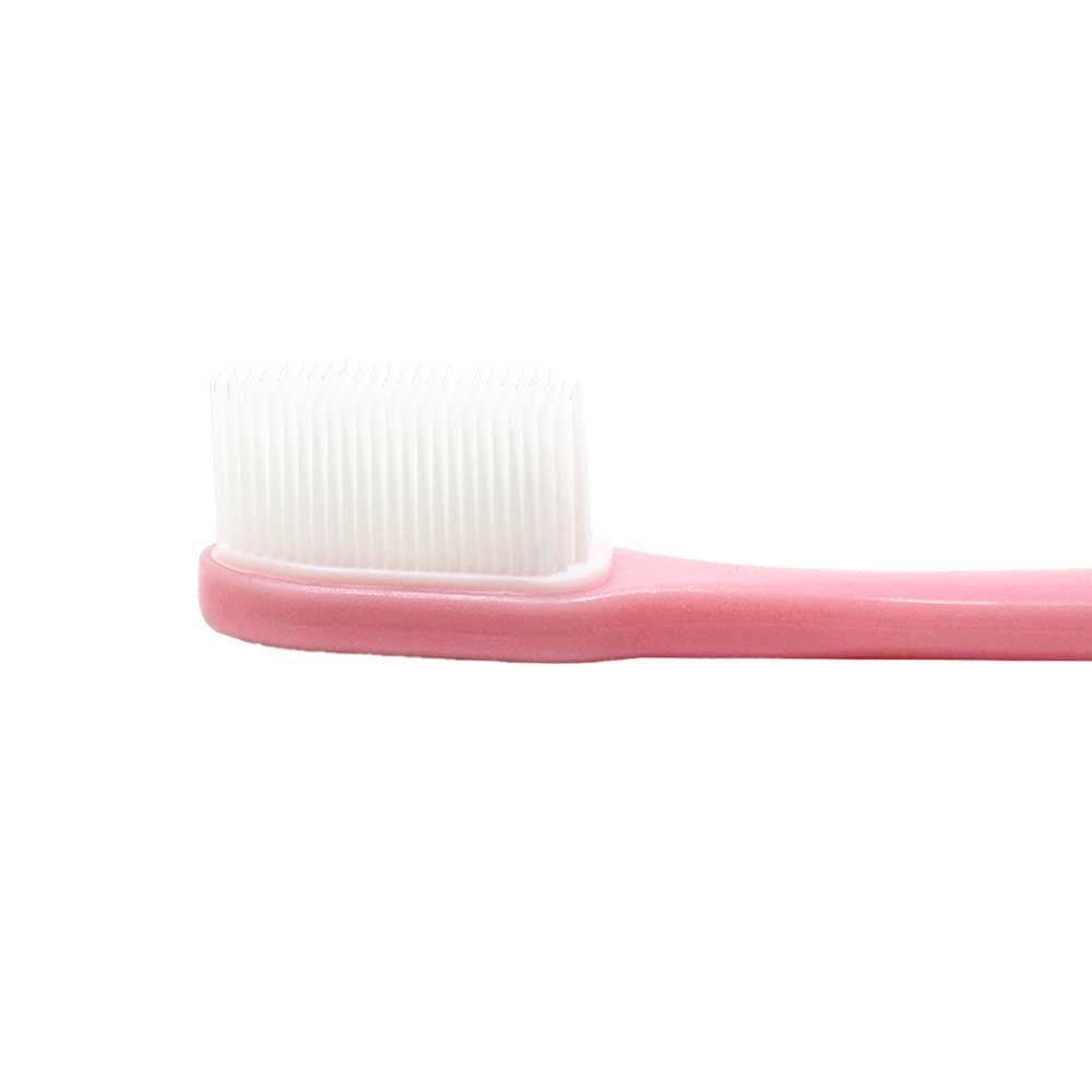 Uno spazzolino da denti rosa con setole bianche dense.