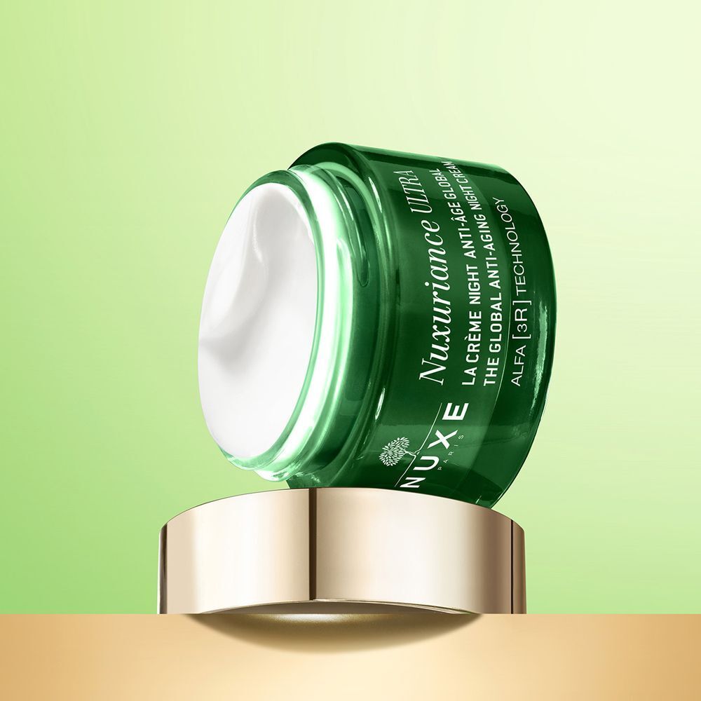 Un vasetto Nuxe Nuxuriance Ultra con crema, posizionato su un piedistallo dorato.