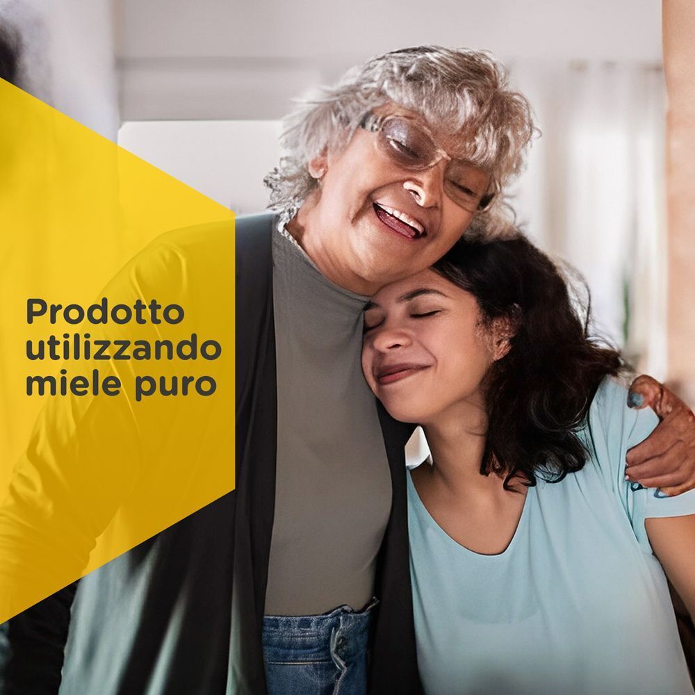 Due donne, una anziana e una giovane, si abbracciano sorridendo. Banner giallo con testo 'Prodotto utilizzando miele puro'.
