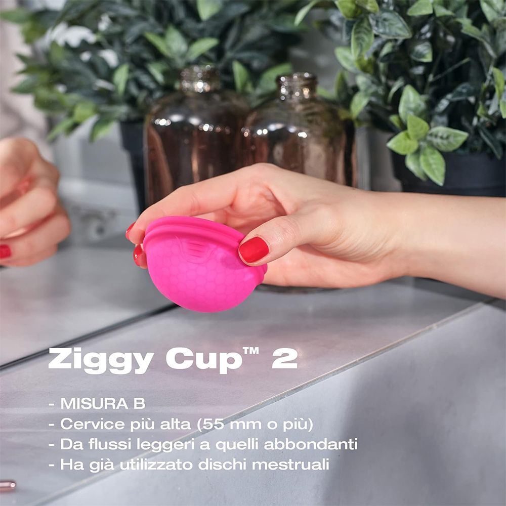 Mano che tiene una coppetta mestruale rosa Ziggy Cup 2, misura B, per cervice alta.