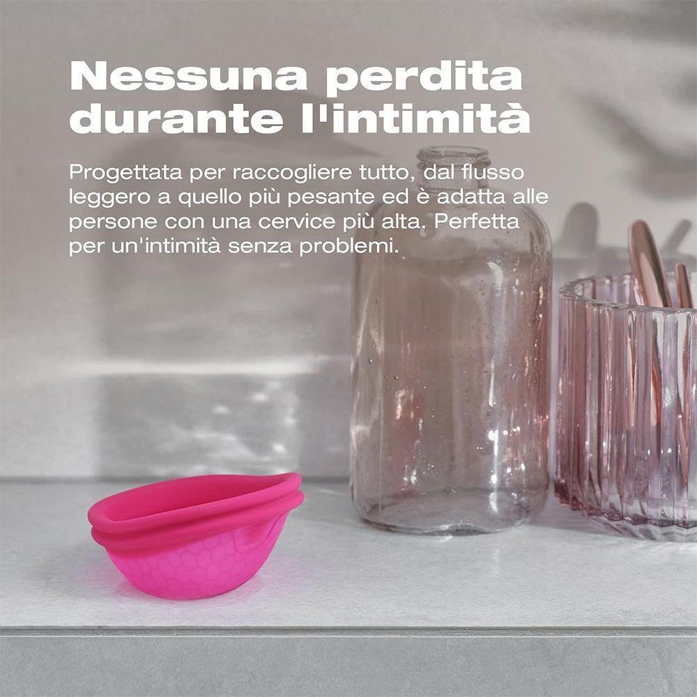 Una coppetta mestruale rosa su uno scaffale. Testo: Nessuna perdita durante l'intimità.