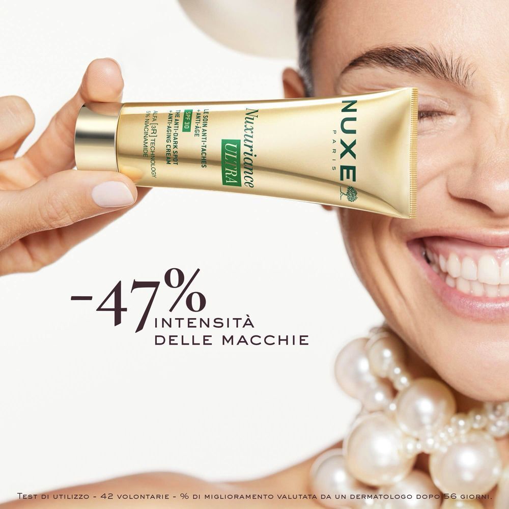 Donna tiene Nuxe Nuxuriance Ultra Crema, con indicazione di sconto sulle macchie.