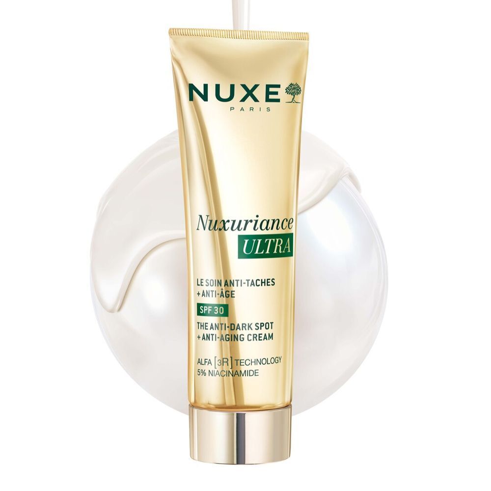 Un tubo dorato di Nuxe Nuxuriance Ultra Crema Anti-Età SPF 30, circondato da crema bianca.