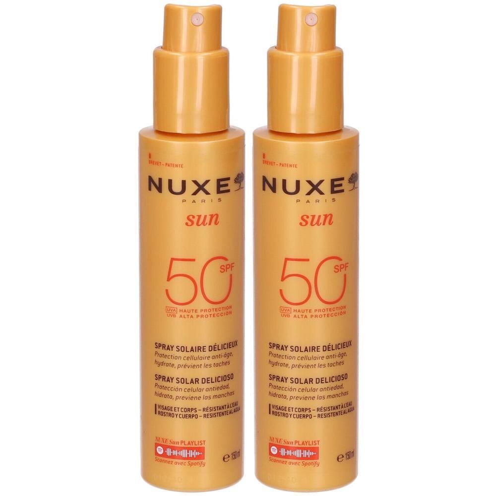 Due flaconi spray Nuxe Sun SPF 50. Flaconi spray arancioni con erogatore bianco.