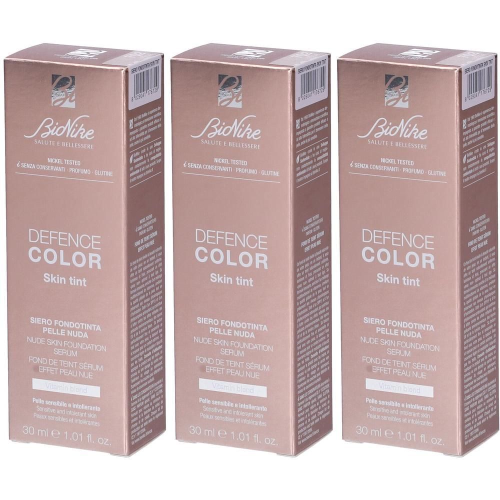 Tre confezioni di siero Bionike Defence Color Skin Tint. Scatola in cartone color pesca con informazioni sul prodotto.