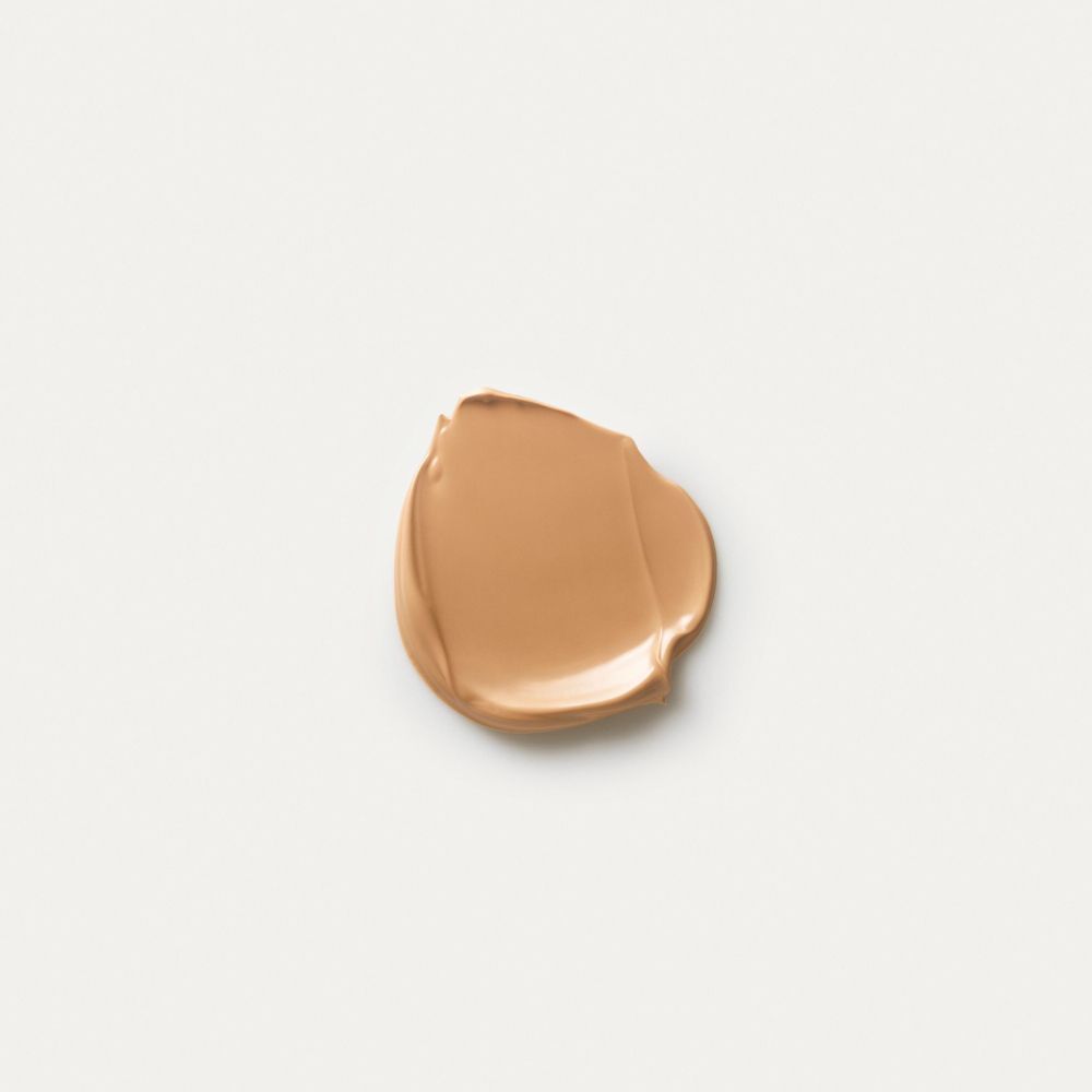 Una macchia di crema color beige chiaro su sfondo bianco.