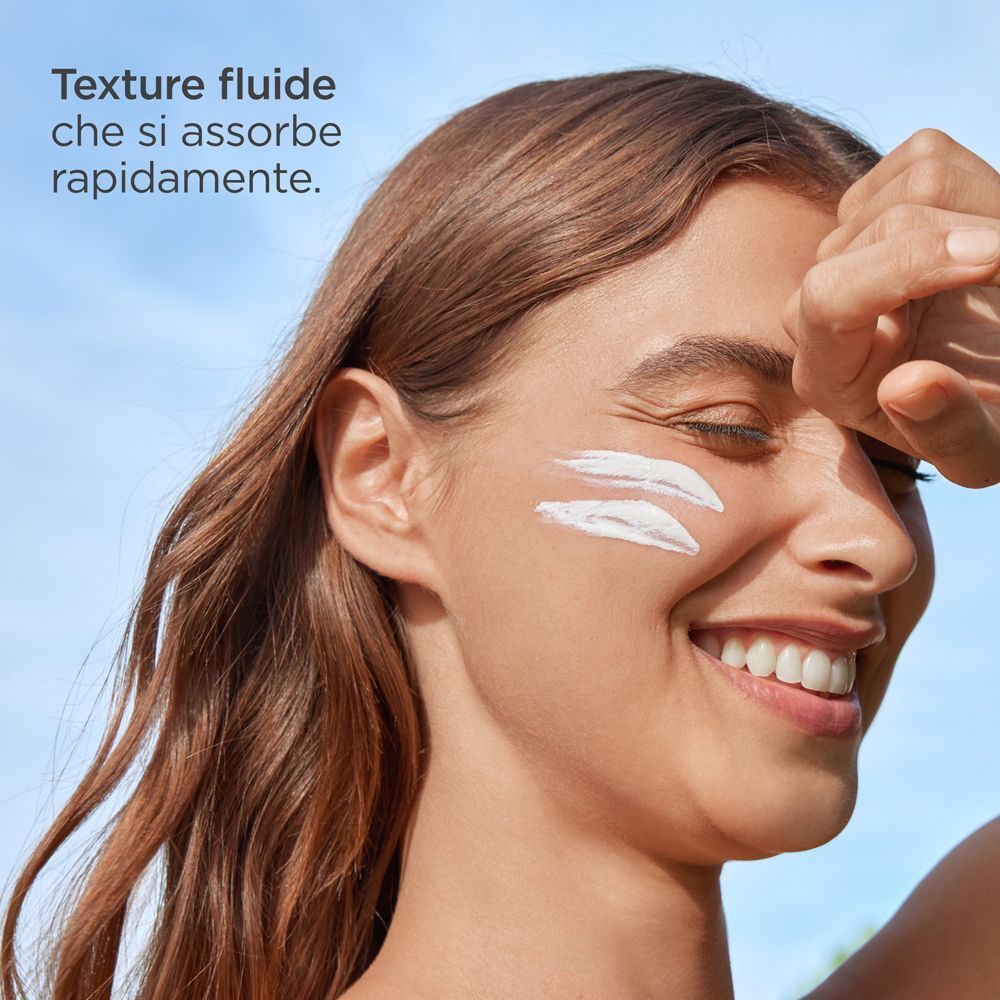 Strisce di crema sul viso di una donna che mostra ISDIN Fotoprotector Fusion Fluid Mineral SPF50.