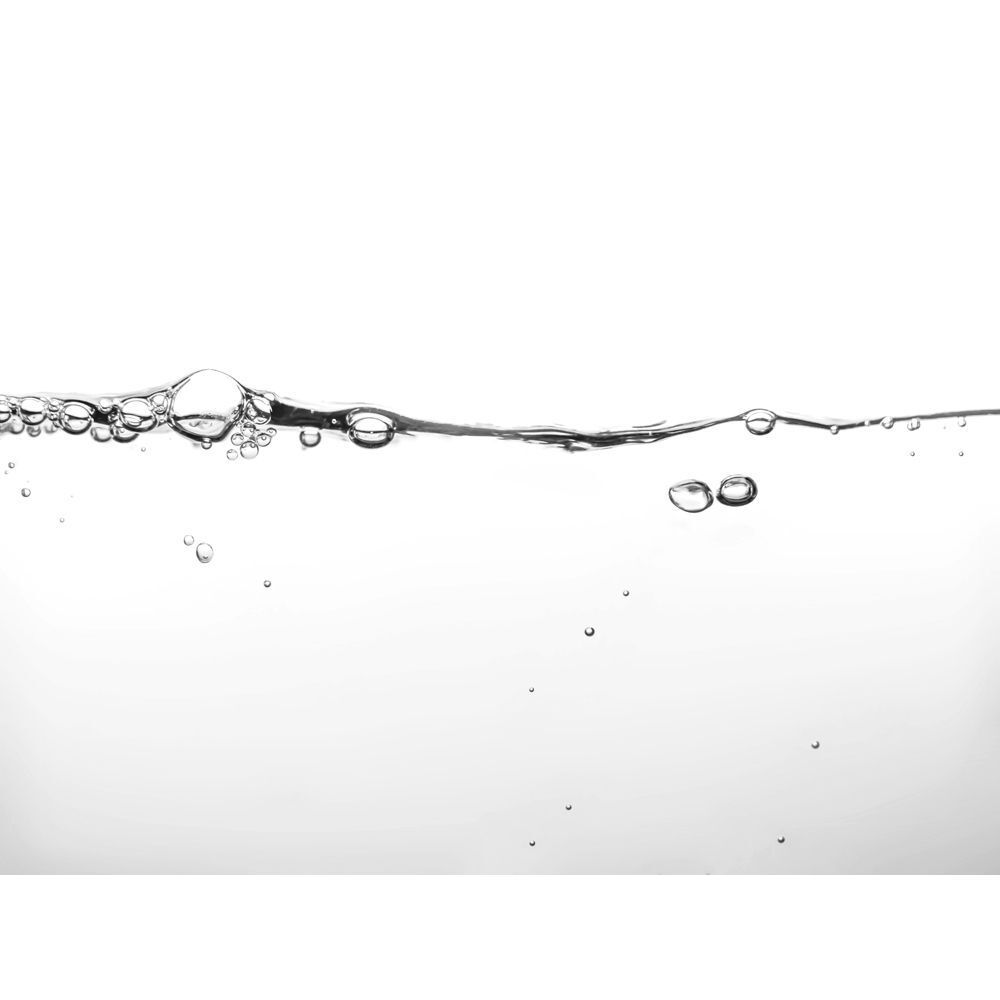 La superficie dell'acqua limpida con piccole bollicine che salgono.