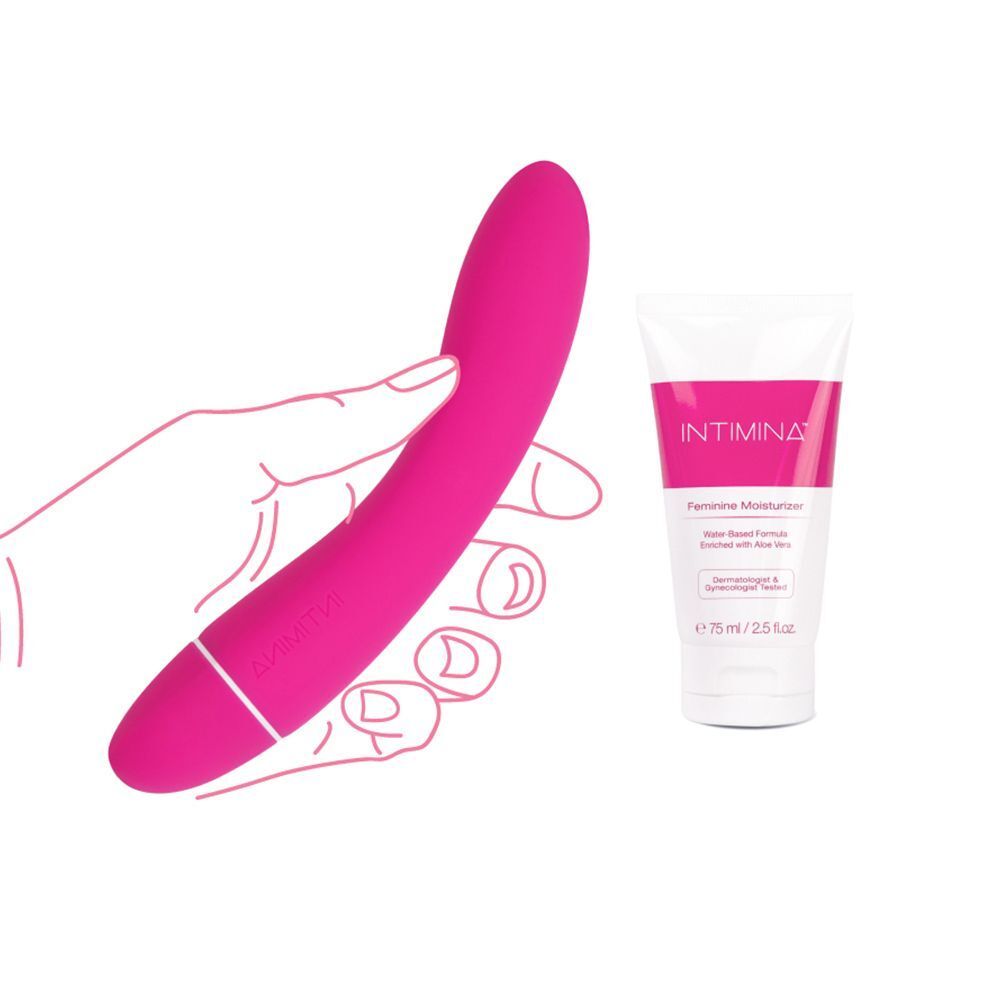 Una mano tiene un vibratore personale rosa accanto a un tubetto di Intimina Feminine Moisturizer.