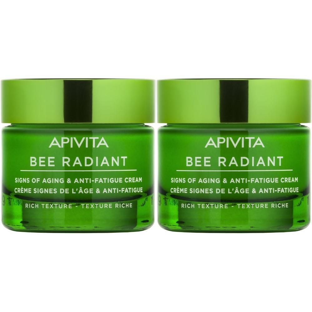 Due vasetti verdi di crema viso APIVITA Bee Radiant, texture ricca.