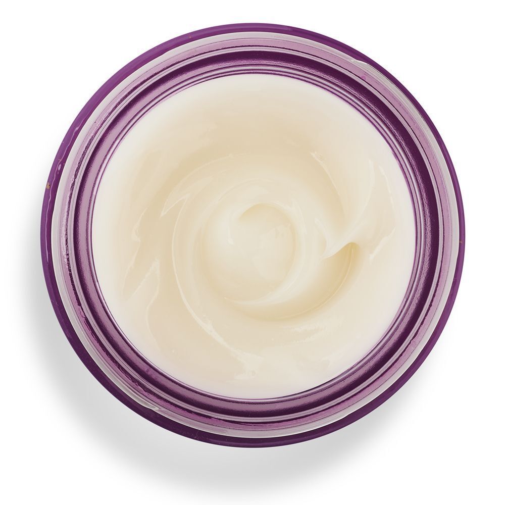 Primo piano della crema viso KORFF Lifting in un vasetto viola aperto.