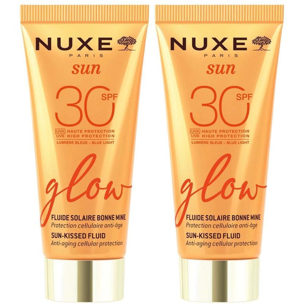 Due tubetti di Nuxe Sun Fluido Solare Viso Glow SPF 30 con tappo dorato.