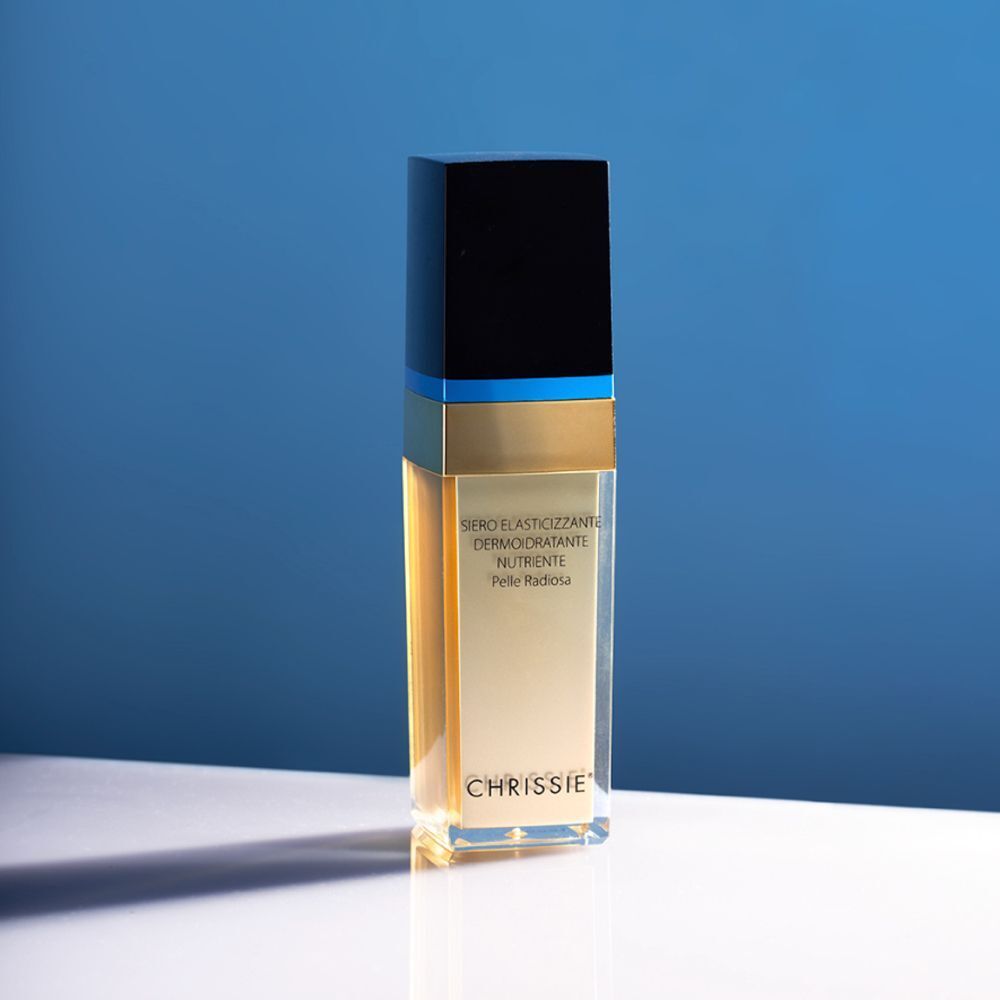 Un flacone di Chrissie Siero Elasticizzante Dermoidratante Nutriente su sfondo blu.
